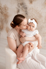 mom and baby, mother gently hugs her baby, kissing him at home, motherhood and caring