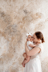 mom and baby, mother gently hugs her baby, kissing him at home, motherhood and caring