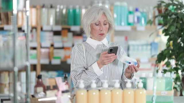  Elderly woman buyer scanning qr code for box of ointment in pharmacy