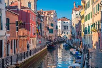 Venice and its narrow streets with canals and colorful houses.