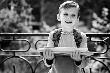 Caucasian boy carrying stack of books
