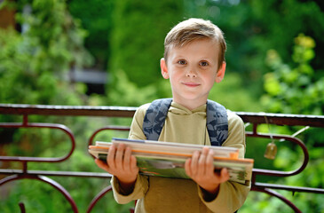 Caucasian boy carrying stack of books