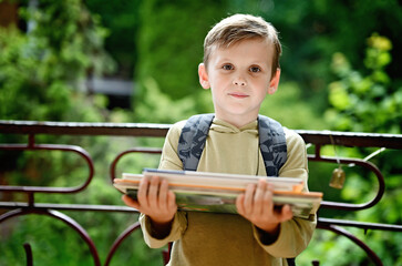 Caucasian boy carrying stack of books