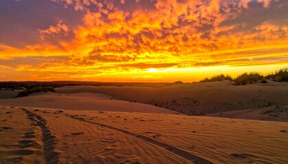 Breathtaking Sunset Over Sand Dunes with Vibrant Orange Sky