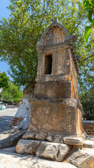 Stone sarcophagus of royal or lion's Lycian tomb made of solid rock. Drywall sarcophagus with handles in form of lion heads on street in Kas, Turkey. Vertical image