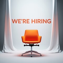 An empty bright orange modern office chair sits center stage under a spotlight with the words we re hiring displayed prominently above it