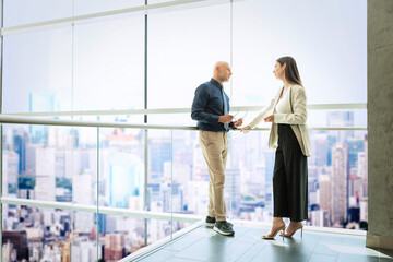 Group of business people in a modern office standing at the glass wall in a moder office and...