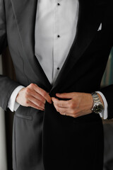 buttoning a beautiful stylish men's suit