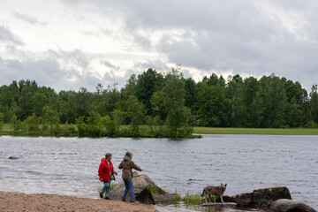 Outdoor activities two women with pet in wild nature near water