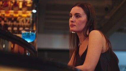 Sitting beautiful woman guest feeling bored waiting friends or couple with drinking mixed vodka in...