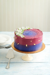 purple and blue cake with white flowers and gold leaf