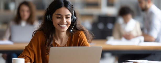 The smiling woman engaging in online learning with a laptop and headset.
