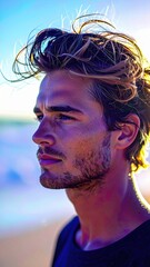 Man with a beard and a black shirt on a beach