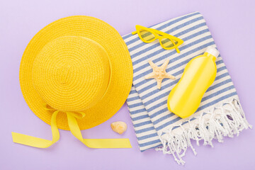 Beach towel with summer accessories on color background, top view