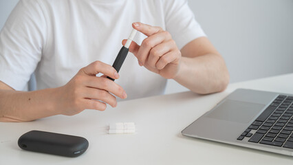 A woman inserts a cigarette stick into a tobacco heating system. Electronic cigarette.