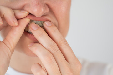 A woman uses chewing tobacco. 