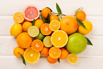 Different citrus fruits on wooden background, top view