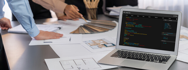 Group of interior architect designer discussing together on blueprint and laptop screen display...