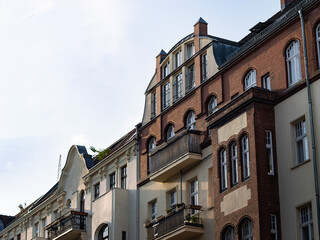 Residential building facade in the style of an old industrial building. Former factory converted to an apartment house in a city. Red brick stones are part of the exterior wall.