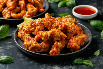 Korean fried chicken with spicy sauce and sesame seeds