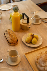 Petit déjeuner appétissant servi sur une élégante table en bois avec chaises en cannage, dans une salle lumineuse et chaleureuse.