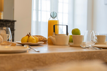 Petit déjeuner appétissant servi sur une élégante table en bois avec chaises en cannage, dans...