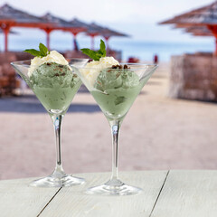 Ice cream on a wooden table by the beach – summer treat, dessert and seaside refreshment concept. Advertising summer desserts, beach snacks, travel, and lifestyle brands themes.