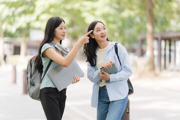 Two Young Women Students Pointing Outdoors