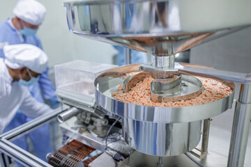 Tablet Production Line and Packaging in Modern Pharmaceutical Manufacturing Facility with Staff