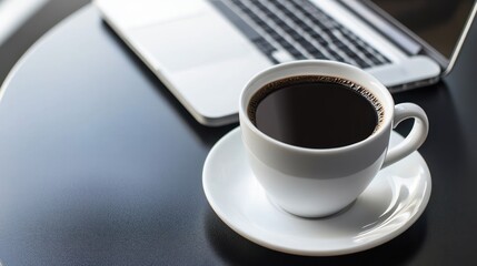 Morning work routine with laptop and coffee on a round dark table