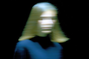 Portrait of a person with blurred features creating a mysterious atmosphere in low-light setting