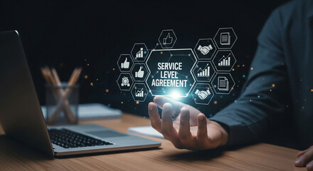 Person presenting service level agreement interface with laptop on a wooden desk surface