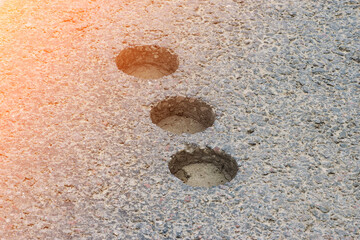inspection round holes in asphalt left after checking the thickness and quality of the asphalt