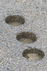 inspection round holes in asphalt left after checking the thickness and quality of the asphalt