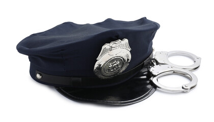 Police cap and handcuffs on white background