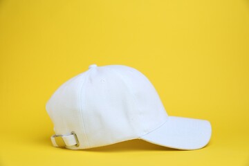 One white baseball cap on yellow background