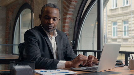 African American middle-aged entrepreneur typing laptop computer business man office businessman...
