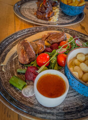 Beautifully presented meat dishes, with fries, dumplings and vegetables