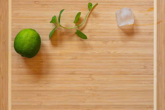 top view of cutting board, fresh lime and ginger on wooden board
