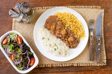 Prato Executivo Estrogonofe de Carne Brasileiro com Arroz, Batata Palha e Salada em Mesa de Madeira