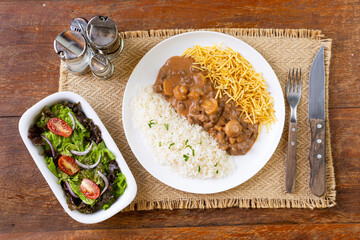 Prato Executivo Estrogonofe de Carne Brasileiro com Arroz, Batata Palha e Salada em Mesa de Madeira