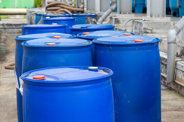 Row of Blue Plastic Drums in Industrial Setting