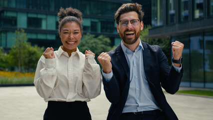 Two happy multiracial business colleagues partners winners African American woman businesswoman...