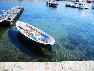 A serene and picturesque view of boats gently floating in the calm waters of the port on Elba Island, Italy. Ideal for conveying relaxation, coastal living, and Italian island life.