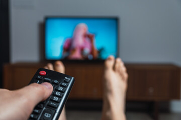Listening to music on TV while relaxing at home.  Person enjoying music or concert on television...