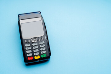 Black cell phone with a green button on the top right. The phone is on a blue background
