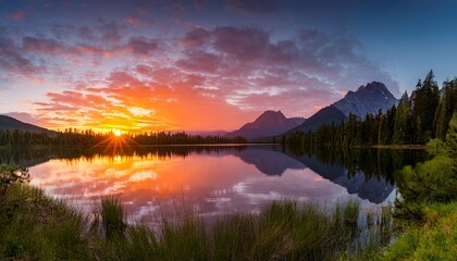 scenic mountain lake reflecting sky and peaks under sunlight