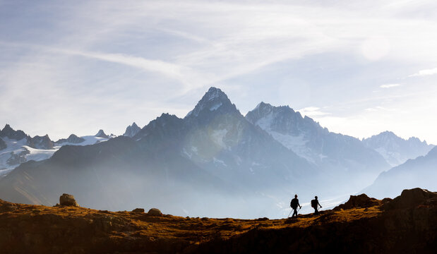 Two hikers walking above Lac de Cheserys in the French Alps near Chamonix. Scenic Monte Bianco range mountain view with Mont Blanc peaks and alpine adventure vibe - Powered by Adobe