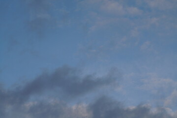 Abendliche Wolken ziehen vorbei in verschiedenen Farben wie blau, grau, beige und weiß
