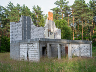 Abandoned building in the middle of the forest. Unfinished construction of a single-family home.